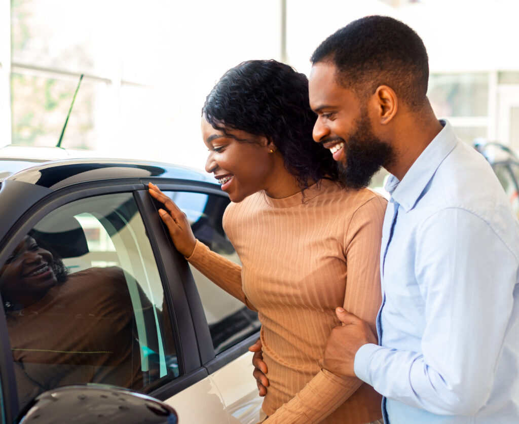 Portrait Of Happy Black Couple In Dealership Center Choosing New Automobile Couple in dealership center choosing 55166697 e1785159666945 1024x837